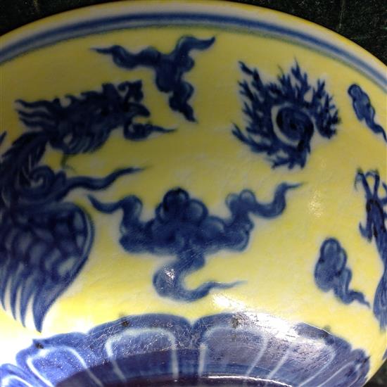 A Chinese yellow ground dragon and phoenix bowl, Xuande six character mark and possibly of the period, 19.5cm, museum restoration, sc